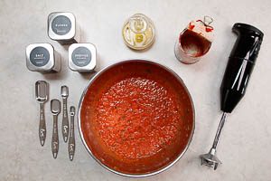 Ganze Tomaten, Tomatenmark, Oliven&ouml;l, Salz, Zucker und Pfeffer dazugeben und alles grob mixen