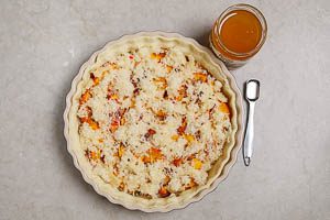 Geriebenen K&auml;se und Honig auf die K&uuml;rbisquiche geben