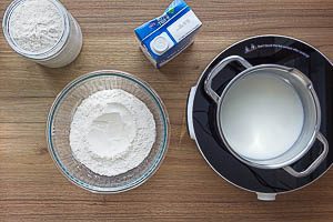 Mehl in eine Schüssel geben und Mulde formen, Milch erwärmen.